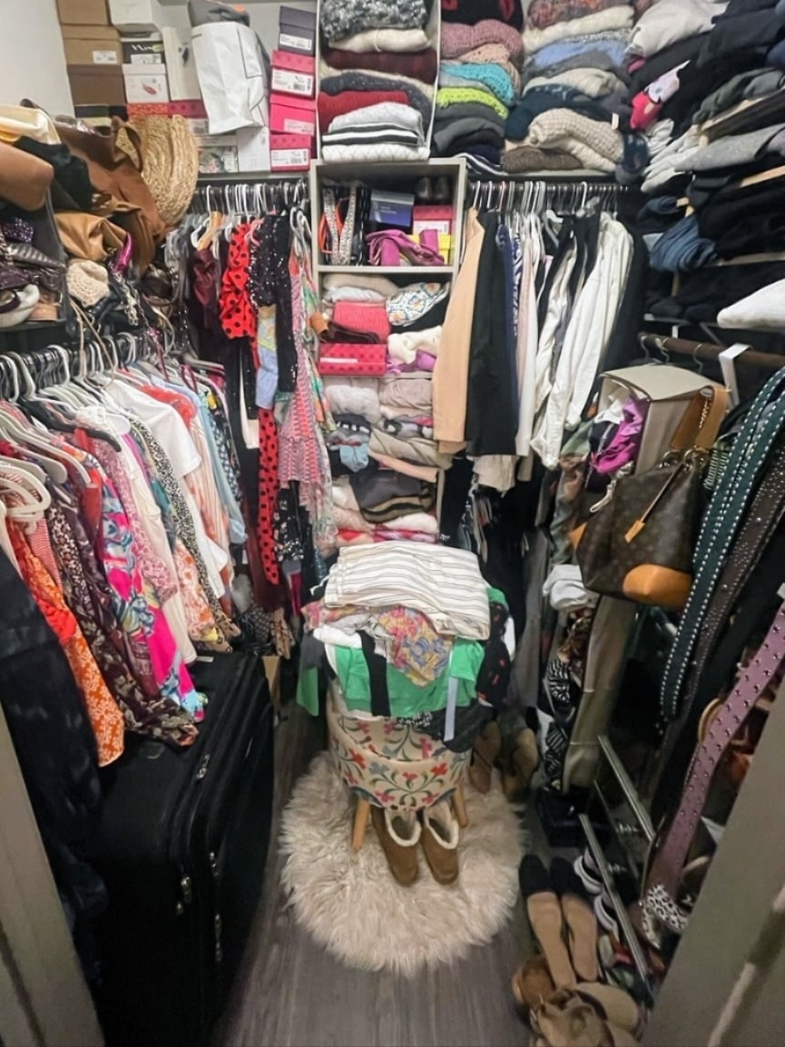 Cluttered walk-in closet packed with clothes, shoes, and accessories